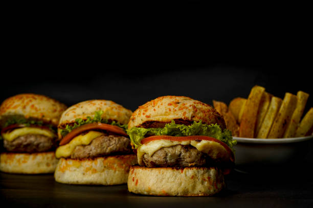 istock Three mini burgers on black background 1383629450