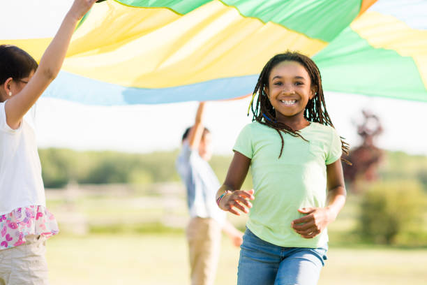 istock Children Running Through a Parachute 1383637374