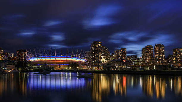 BC Place Stadium lit blue and yellow in solidarity with Ukraine during war February 2022 - Vancouver, BC, Canada - BC Place Stadium lit blue and yellow in solidarity with Ukraine during war vancouver at night stock pictures, royalty-free photos & images