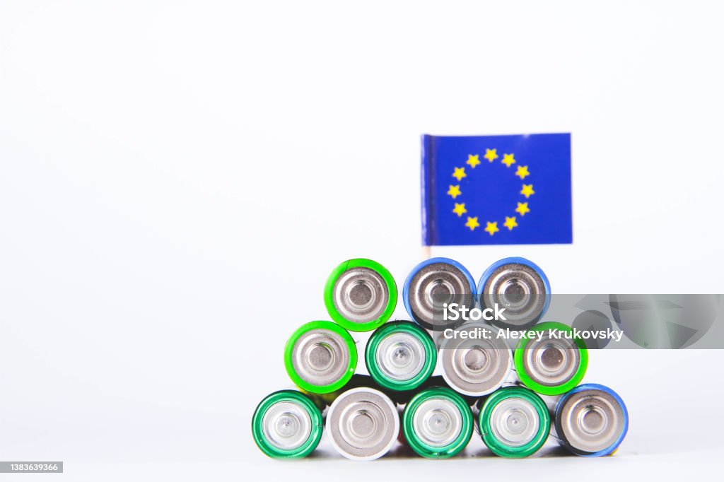 Battery. A lot of batteries on the background of the flag of the country. Battery. AA lot of batteries on the background of the flag of the European Union. Alkaline and alkaline battery. Zinc and salt battery. Lithium import. Waste disposal. AARP Stock Photo