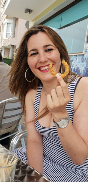 istock beautiful woman eating battered squid on a terrace 1383643350