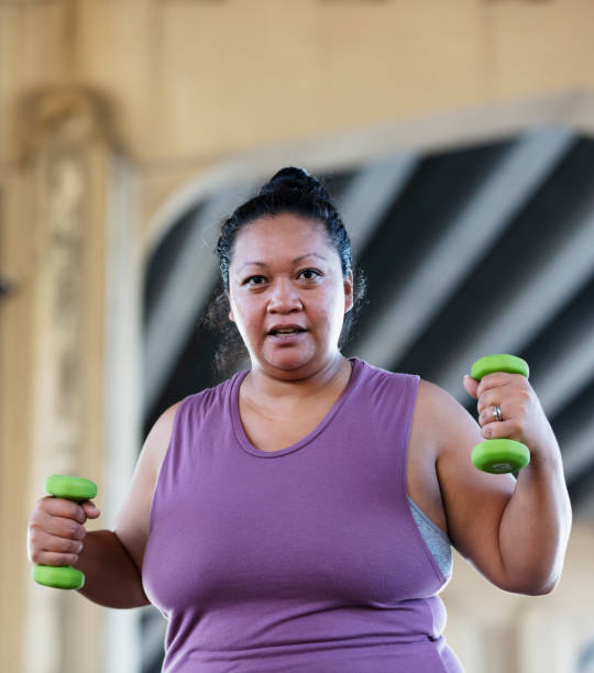 Pacific Islander woman exercising with dumbbells