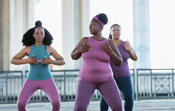 Three multiracial women practicing tai chi in urban area