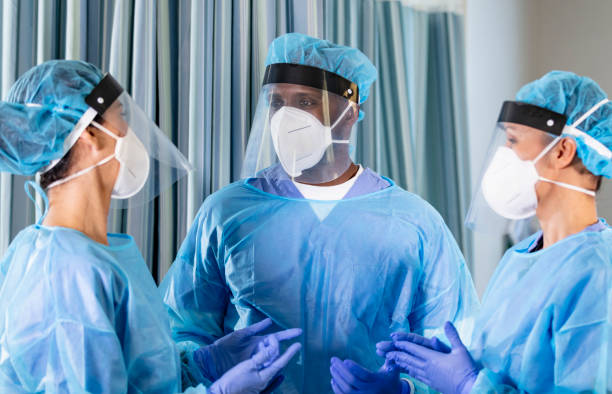 istock Three healthcare workers wearing PPE, conversing 1383692744