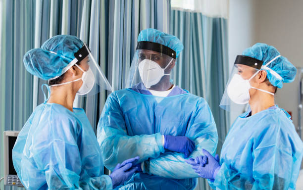 istock Three healthcare workers wearing PPE, conversing 1383692746