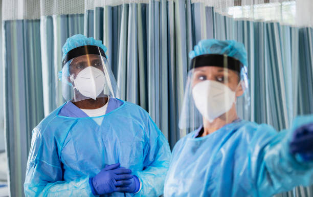 istock Two multiracial healthcare workers in PPE, working 1383692788