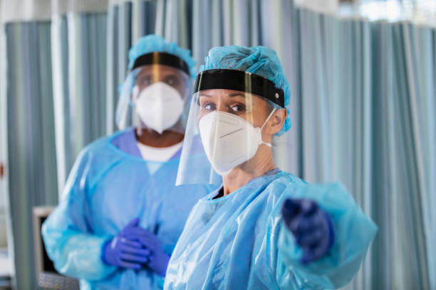 istock Two multiracial healthcare workers in PPE, concerned 1383692796