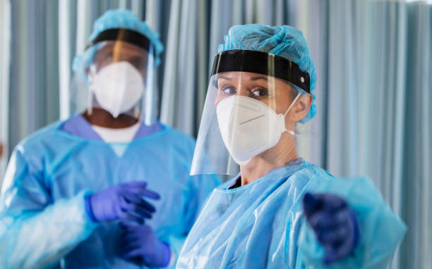 istock Two multiracial healthcare workers in PPE, overworked 1383692797