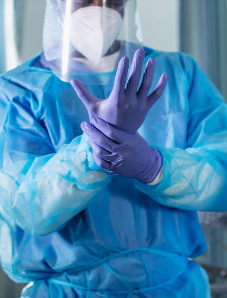 istock African-American healthcare worker putting on PPE 1383693010