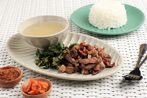 Se'i Sapi o Beef Sei es carne de res ahumada tradicional de Indonesia, servida con hojas de yuca hervidas y Sambal Luat o Sambal Matah. photo