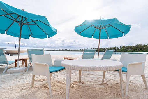 Table and lounge chairs at tropical beach -- Tropical beach holiday and vacation scene