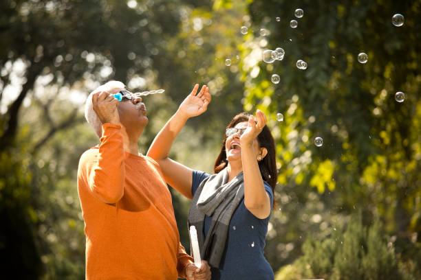 istock Senior couple blowing bubbles at park 1383705826