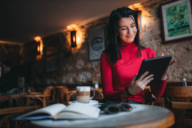 istock Businesswoman using digital tablet at a cafe 1383707212