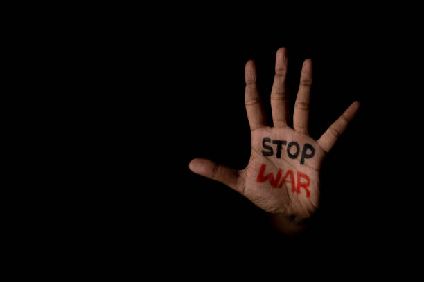 istock unrecognizable hand with stop war written showing with copy space in dark background - concept of independence and freedom 1383708953