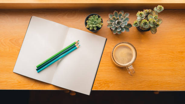 istock Coffee Morning,Coffee in a mug on a wooden table with a notebook 1383713500