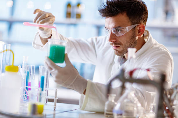 istock Male chemist mixing liquids in laboratory. 1383720807
