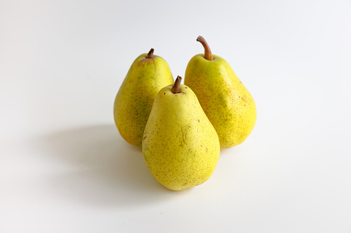 Three whole Yellow pears on white background, organic food, studio shot
