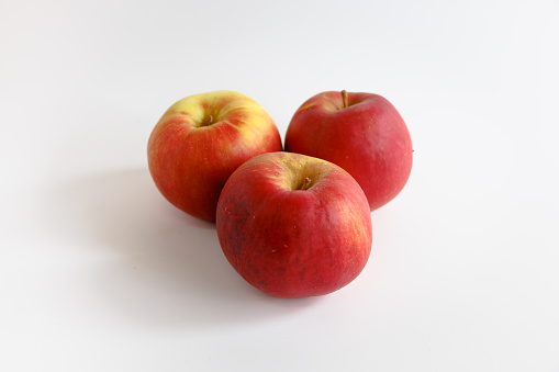 Three whole red apples on white background, Idared, organic food, studio shot