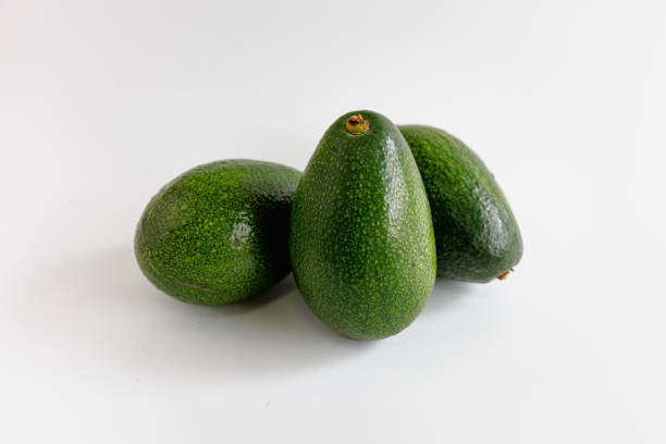 istock Three whole green avocados on white background 1383730760