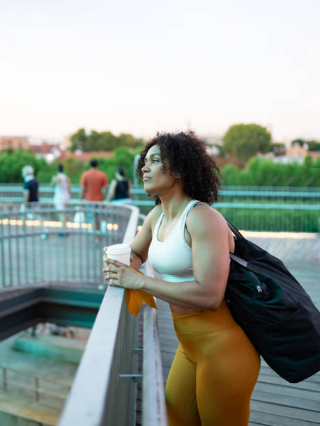 istock sporty woman drinks coffee serious after training sunset 1383740697