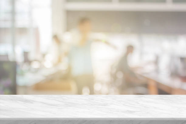 istock White stone marble table top and blurred building office abstract background. Interior banner show with desk backdrop counter blur work people in workplace can used for display or your products. 1383740706