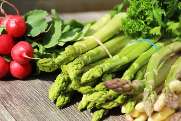 istock Green and white asparagus decorated on a rustic wooden table 1383747666