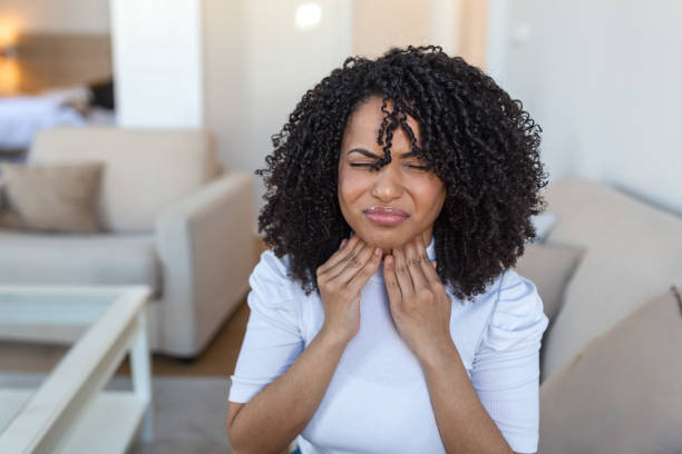 close-up de jovem esfregando suas amígdalas inflamadas, problema de amigdalite, cortado. mulher com problema na glândula tireoide, tocando o pescoço, menina tem dor de garganta - tonsillitis - fotografias e filmes do acervo