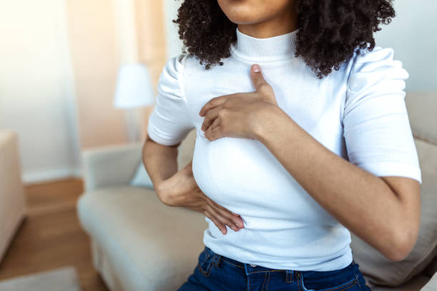 mujer afroamericana que revisa la mano en su seno para detectar signos de cáncer de seno. la mujer sufre de dolor en el pecho. eeb o autoexamen de mamas. pautas para detectar cáncer de mama. - breast fotografías e imágenes de stock