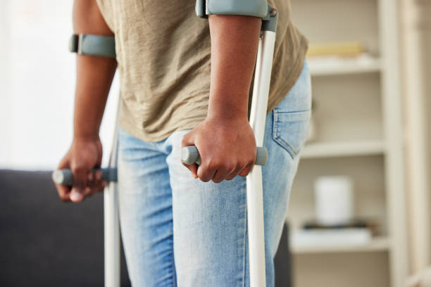 Shot of a unrecognizable man using crutches at home Life's ups and downs walking aids stock pictures, royalty-free photos & images