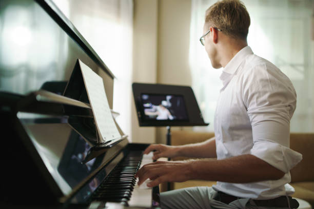 Scene of piano lessons online training or E-class learning while Coronavirus spread out or covid-19 crisis situation, vlog or teacher make online piano lesson to teach students pupils learn from home.