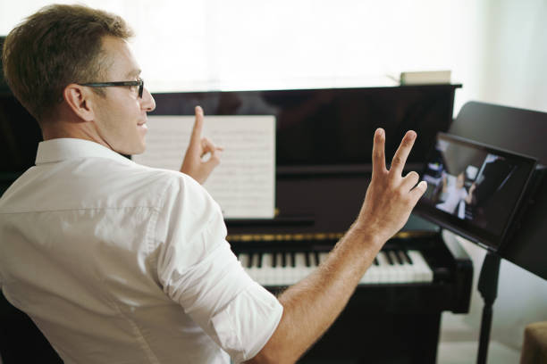 istock Scene of piano teacher cheer up his student while have lessons online training or E-class learning. Music learning from online network to teach students pupils learn from home. Social distancing. 1383761047
