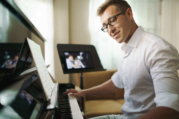 istock Scene of piano lessons online training or E-class learning while Coronavirus spread out or covid-19 crisis situation, vlog or teacher make online piano lesson to teach students pupils learn from home. 1383761057