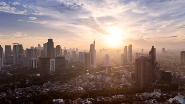 Drone view of misty skyscraper in Jakarta city JAKARTA - Indonesia. February 15, 2022: Drone view of misty skyscraper in Jakarta city with sunrise time background jakarta skyline stock pictures, royalty-free photos & images