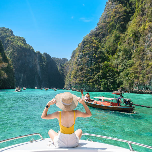 femme touriste en bateau, voyageuse heureuse se relaxant dans la lagune de pileh sur l’île de phi phi, krabi, thaïlande. monument exotique, destination asie du sud-est concept de voyage, vacances et vacances - southeast asia photos et images de collection