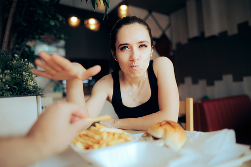 Unhappy woman not willing to share her meal with her date