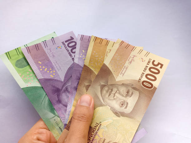 istock A hand holding indonesian currency in the white background 1383767699