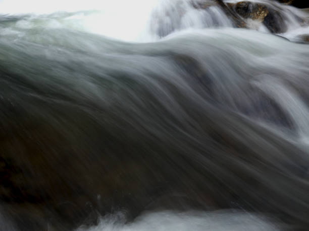 istock Closeup of Motion-Blurred Water Rapids Flowing over a Cobble 1383790258