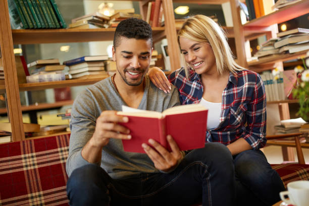 istock Young multi-ethnic student couple enjoy book reading in the library 1383791933