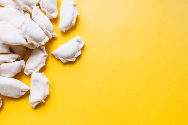 traditional Russian frozen dumplings pelmeni over yellow background stock photo
