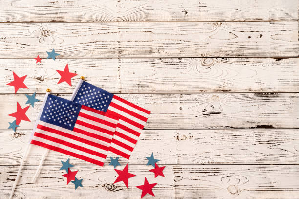 istock USA national flags on white wooden background 1383815904