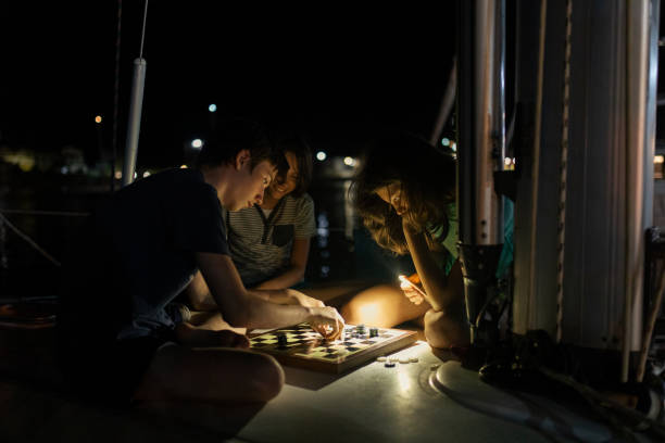 istock Children playing board strategic game on yacht at night 1383816337