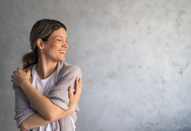 istock Smiling loving young woman hugging oneself 1383821251
