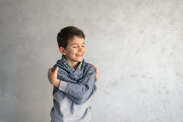 istock Smiling loving young boy hugging oneself 1383821358