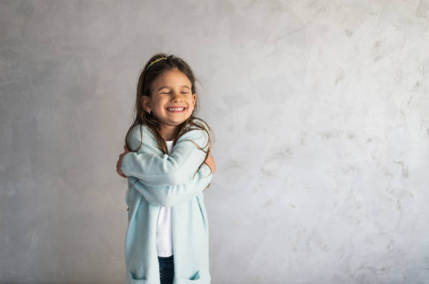 istock Smiling loving young girl hugging oneself 1383821852