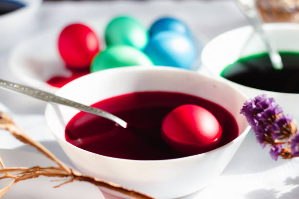 istock Painted eggs in a white t-shirt top view on a white table, preparation 1383822854