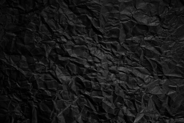 istock Textured crumpled black paper background. 1383823577