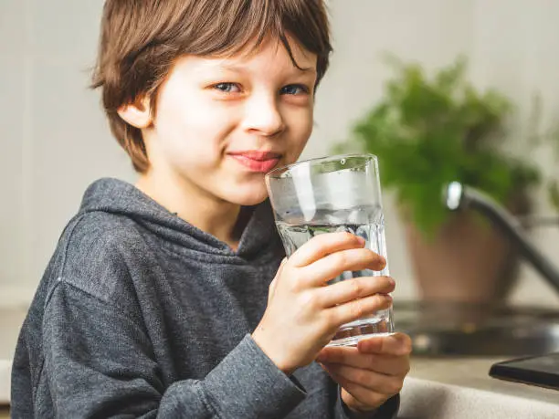 Photo of Kid drinking clean tap water at home