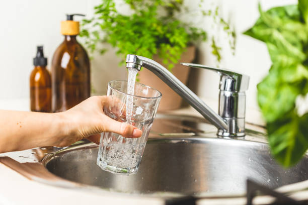 きれいな水道水でガラスをファイリングする女性の手 - water faucet running water glass ストックフォトと画像