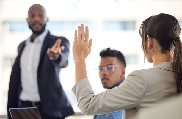 オフィスでの会議中に手を挙げるビジネスウーマンのクローズアップショット - hand raised asking women businesswoman ストックフォトと画像