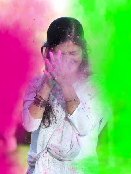 portrait of happy indian girl celebrating holi with powder colours or gulal. concept of indian festival holi. - face powder exploding make up dust imagens e fotografias de stock